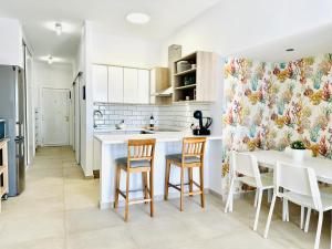 a kitchen with a counter and chairs and a table at Pambnb - Modern Beachfront Apartment Hideaway in Santa Cruz de Tenerife