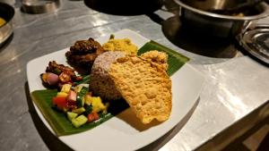 a white plate with food on a table at Ariya Tissa in Tissamaharama