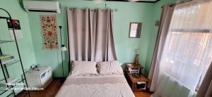 um pequeno quarto com uma cama e uma janela em Yellow House em Coco
