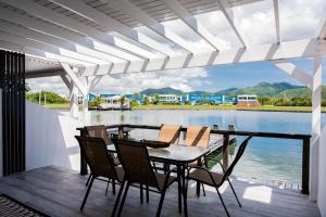 a table and chairs on a deck with a view of the water at Villa 409C in Jolly Harbour