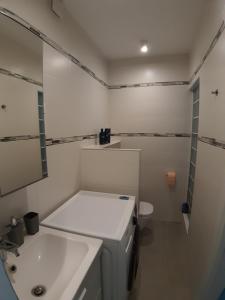 a white bathroom with a sink and a toilet at Cozy apartment close to the airport in Budapest