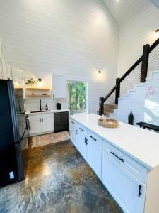 a kitchen with white cabinets and a black refrigerator at the RISER - BRAND NEW Modern Cabin in Broken Bow in Broken Bow