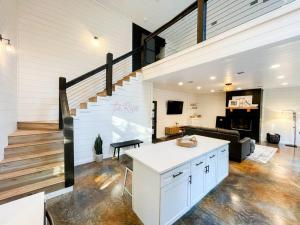 a living room with a staircase and a white counter at the RISER - BRAND NEW Modern Cabin in Broken Bow in Broken Bow