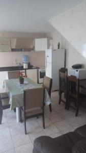 een keuken met een tafel en stoelen en een koelkast bij voltamos a funcionar casa da mãe Aparecida in Aparecida