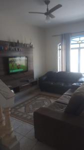 a living room with a couch and a flat screen tv at Casa da Mãe próximo a Basílica in Aparecida