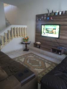 een woonkamer met een bank en een televisie bij voltamos a funcionar casa da mãe Aparecida in Aparecida
