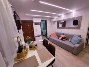 a living room with a couch and a dining table at Dénár Apartmanház in Veresegyház