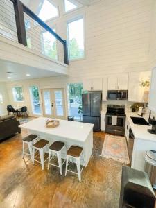 a large kitchen with a white table and chairs at the RISER - BRAND NEW Modern Cabin in Broken Bow in Broken Bow