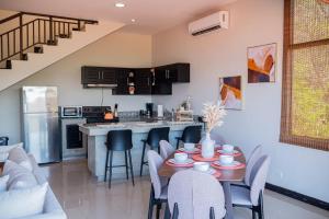a kitchen and living room with a table and chairs at Sunset Harmony, Your Escape at Playa Hermosa in Sardinal