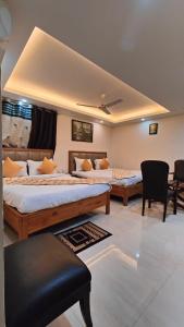a hotel room with two beds and a chair at THE RED DIAMOND NEAR IGI AIRPORT new DELHI in New Delhi
