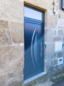 una porta blu sul lato di un edificio in pietra di Casa da Martha a Celorico da Beira