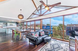 a living room with a ceiling fan and a table at Beachview Bungalow Warrnambool in Warrnambool