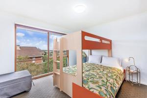 a bedroom with a bunk bed and a large window at Beachview Bungalow Warrnambool in Warrnambool