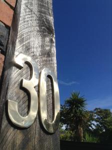 um grande sinal de metal no lado de uma árvore em Heriot Lane City Apartments em Dunedin