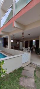 a house with a patio and a swimming pool at Solar de Manguinhos Flat in Manguinhos