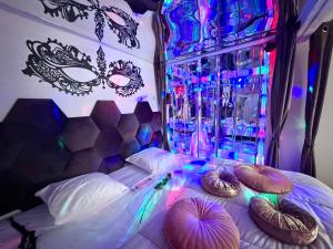 a bedroom with a bed with masks and colored lights at Caporizon-Lov'BNB-La seule Love House de Dordogne in Biras