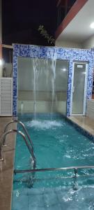 a swimming pool with a water fountain in it at Solar de Manguinhos Flat in Manguinhos