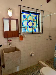 グアタビータにあるVilla el tramontoのバスルーム(バスタブ付)、ステンドグラスの窓が備わります。