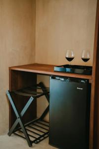 zwei Gläser Wein auf einem Tisch mit einem Kühlschrank in der Unterkunft Equ Hotel de Tierra in El Porvenir