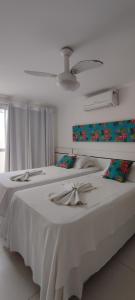 a bedroom with a large bed with white sheets at Solar de Manguinhos Flat in Manguinhos
