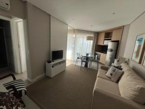 uma sala de estar com um sofá e uma televisão em Estanconfor Vista Mar em Santos em Santos mais 52 fotografias