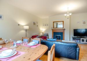 ein Wohnzimmer mit einem Tisch und einem blauen Sofa in der Unterkunft Wagtails in Blythburgh