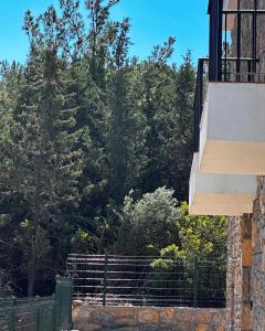 a balcony of a house with a fence and trees at Villa Carian Trail Datca , Kargi Koyu , plaja yakin in Datca