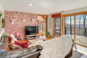 een woonkamer met een bank en een bakstenen muur bij Wilmington Retreat with Deck, Lake Views and Game Room in Wilmington