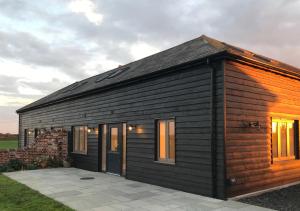 a small wooden house with a patio at Swallows Roost in Sudbury