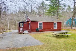 a red cabin with a picnic table in front of it at Massachusetts Cabin Rental Near Hiking and Skiing! in Ashburnham