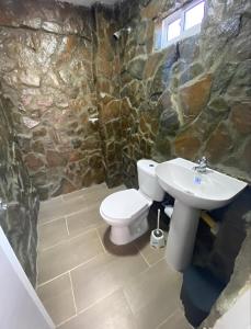 a stone bathroom with a toilet and a sink at Apartahotel in Taganga