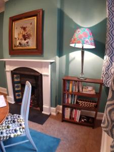 a living room with a fireplace and a lamp at Edwardian Terrace in Royal Sutton NEC BHX in Birmingham