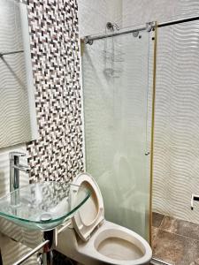 a bathroom with a toilet and a glass shower at Apartamentosla23 in Valledupar
