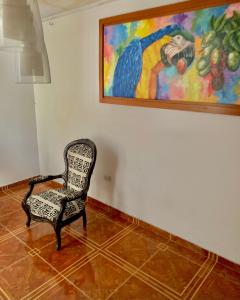 a chair in a room with a painting on the wall at Apartamentosla23 in Valledupar