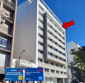 un edificio alto con una bandera roja delante de él en PRESNO 01- piso 9 bien ubicado, en Montevideo