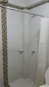 y baño con ducha y puerta de cristal. en ALIIKA HOTEL en Albania