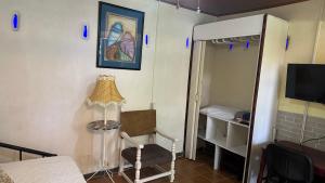 una camera con lampada, sedia e specchio di Owl House a Piedades