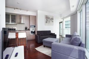 uma sala de estar com um sofá e uma cozinha em Downtown Toronto condo 2 bedrooms with parking near Rogers Center em Toronto