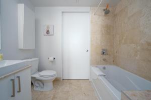 een badkamer met een toilet, een bad en een wastafel bij Downtown Toronto condo 2 bedrooms with parking near Rogers Center in Toronto