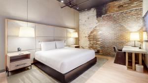 a bedroom with a bed and a desk and a sink at Studio 154 Luxury Hotel in Nashville