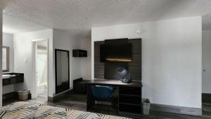 a bedroom with a desk and a bed and a room at Motel 6 Houston, TX - Medical Center - NRG Stadium in Houston