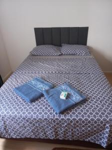 a bed with two blue towels on top of it at Apartamento in Paranoá