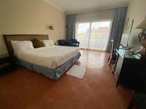 een hotelkamer met een bed en een groot raam bij INGOING Marina in El Alamein