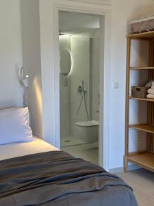 a bedroom with a bed and a bathroom with a shower at Papanestoras Apartments in Kardamili