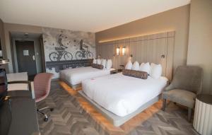 a hotel room with two beds and a chair at Coast Victoria Hotel & Marina by APA in Victoria