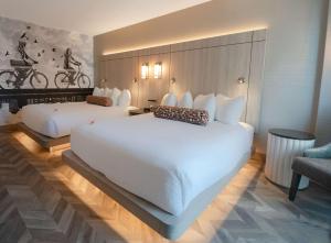 una camera d'albergo con due letti e una sedia di Coast Victoria Hotel & Marina by APA a Victoria