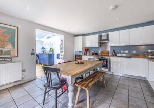 cocina con mesa de madera y 2 sillas en Welcome To Your Home en Londres