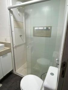 a bathroom with a toilet and a glass shower at Apartamento de luxo no centro in Belém