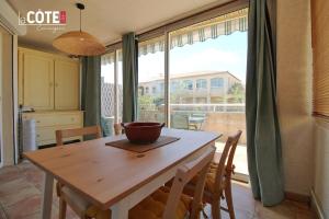 a table and chairs in a kitchen with a large window at Fidji bis in Sausset-les-Pins