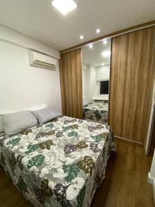 1 dormitorio con 1 cama con manta de flores en Apartamento de luxo no centro, en Belém